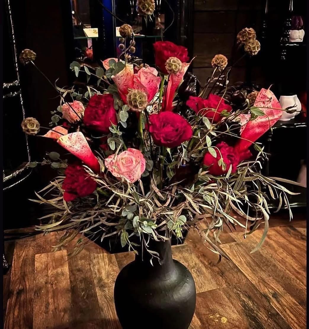 Candles, skulls, and dark florals arranged for a ceremonial centerpiece.