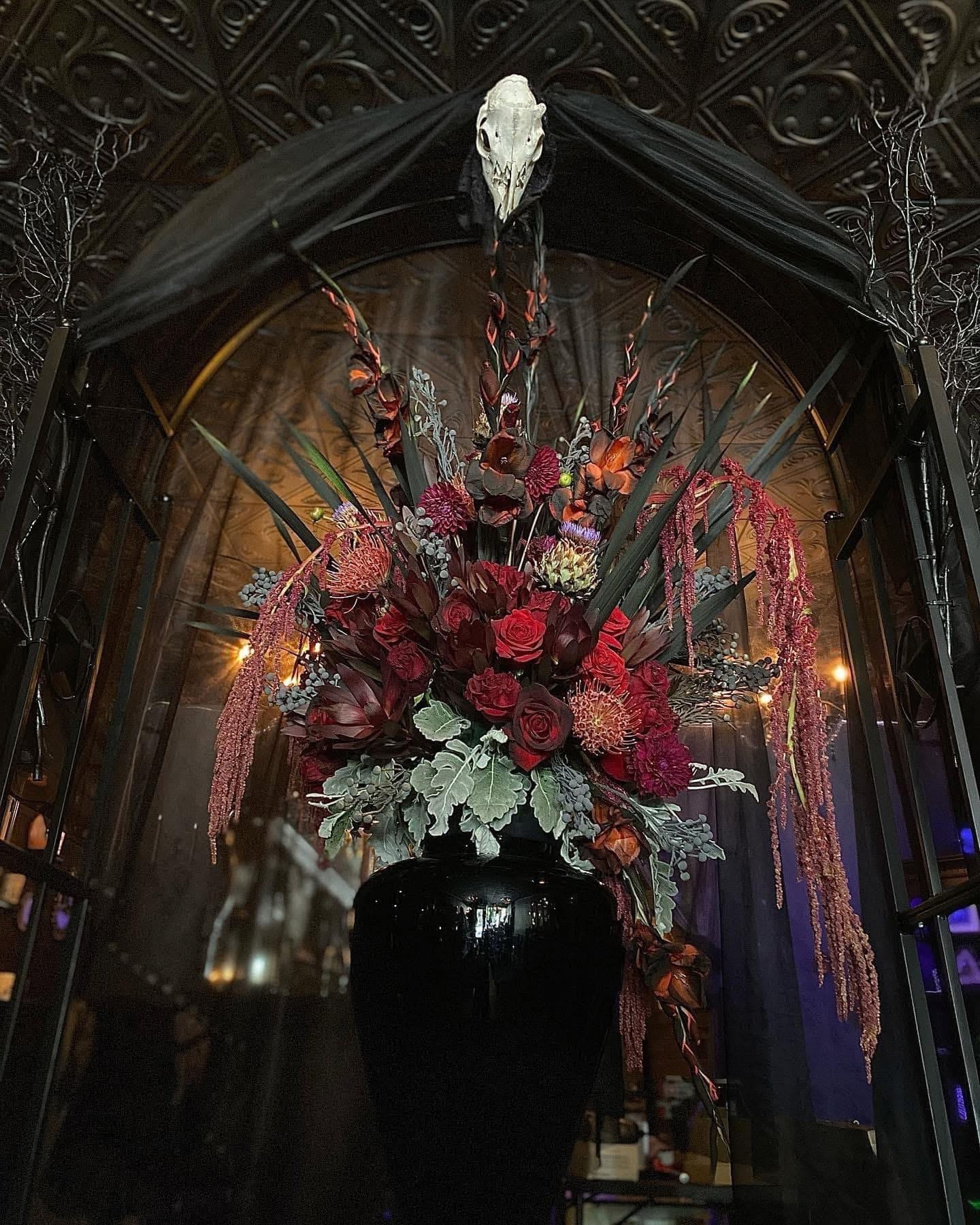 Florist arranging dark red roses at Arcane Arrangements